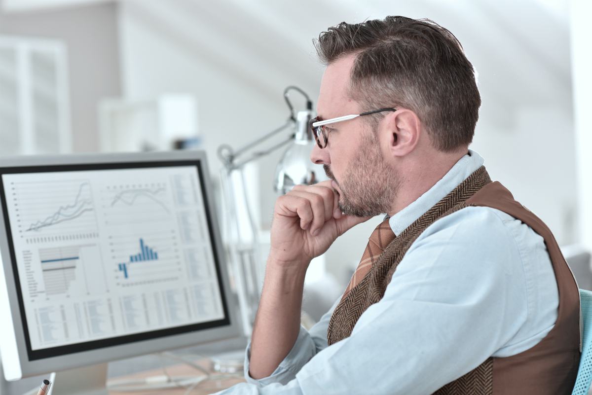businessman looking at computer | Four Laws to Build a Sales Cadence | pipeline management